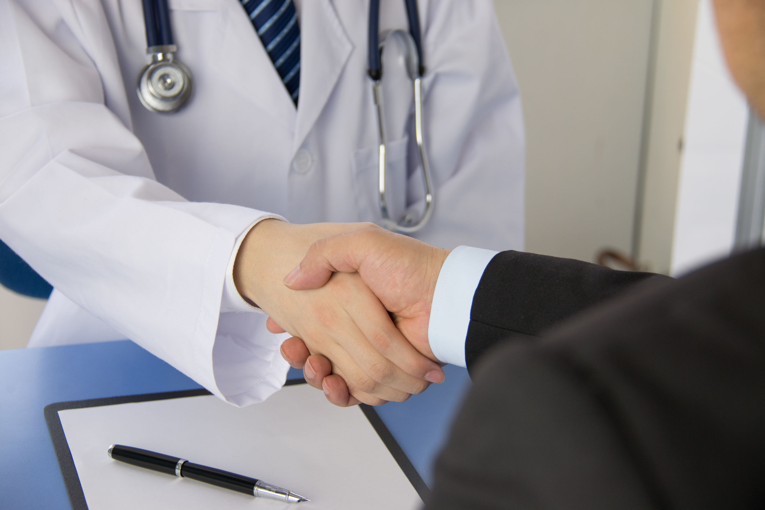 Doctor and businessman shaking hands